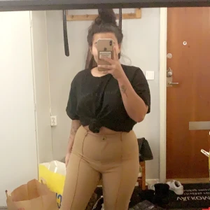 Kostymbyxor - Brun/ beiga byxor med två sömmar fram. Väldigt sköna är lite långa men jag är 158 har en slits ner till. Storlek L