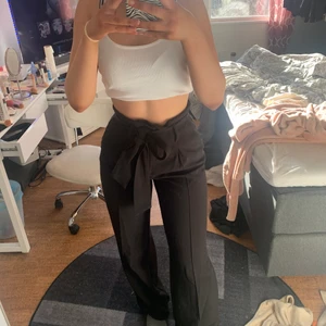 Svarta kostymbyxor - Kostymbyxor från Bikbok! Skärpet är avtagbart och byxorna är jättefina både med och utan det. Passar mig som är S/M bra!