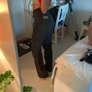 Wrangler jeans  - Ett par svarta jeans från wrangler som är raka i modellen med ett hål på knät, 150 + frakt 