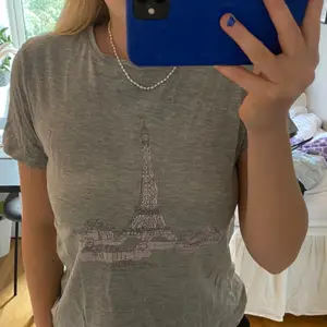 Grå T-shirt med Eiffeltorn tryck köpt på nakd. Skönt material och storlek XS🤍Köparen står för frakten!