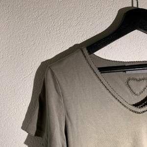 Supersöt grå/grön T-shirt med fina ”spets”detaljer samt ett hjärta i ryggen! Köparen står för frakten💗💗