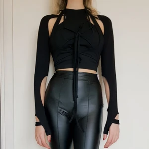 Svart cutout crop top  - Svårt långärmad cutout crop top med knytdetaljer. Kommer i 2 delar, ärm-delen är justerbar. Kan bäras separat. Endast använd ett fåtal tillfälle, mycket bra skick.   Markerad strl S, passar XS-S  95% bomull 5% spandex Perfekt party-topp! 🖤