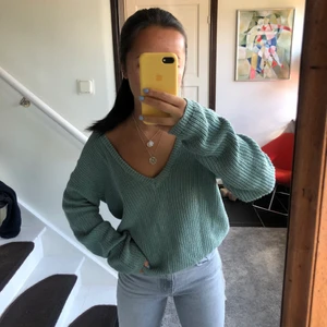 stickad tröja - V-ringad stickad tröja  ifrån NA-KD. V-ringningen ska egentligen vara i ryggen men går att vända på och använda framtill. Använd bara några gånger och säljs i därför i ett gott skick. Stl är XXS men skulle säga att den är ganska mycket större än så, passar absolut som både XS och S. Pris: 120kr, frakt ingår inte