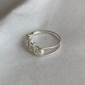 Handgjord ring med pärla. Tråden är silverpläterad. 19mm i innerdiameter. Fri frakt.