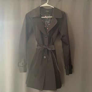 Svart vår/höst kappa - Unik svart vår/höst kappa från vila. Bra ärmlängd och kan knytas i midjan. Har fickor. Har en lags hourglass fit. Storlek XS / S