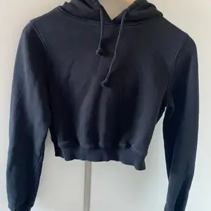 En svart hoodie som är kroppad från Nelly. 