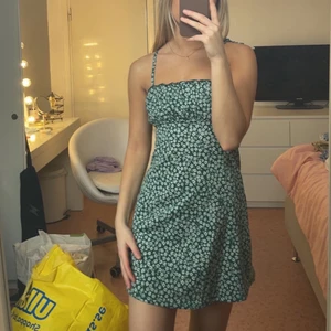 Grön klänning - Grön klänning med blommönster från H&M i storlek XS. Köparen står för frakt 