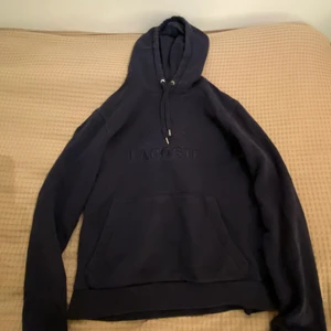 Lacoste Hoodie i storlek S - En skit snygg Lacoste Hoodie i färgen mörkblå som inte finns i butik längre. Skulle säga att den är i ett 7/10 skick och är riktigt bekväm. 