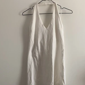 Vit Halter neck - Ett vitt linne med halter neck. Har ett dubbel lager vid bysten så att man slipper BH och ej blir genomskinligt. 