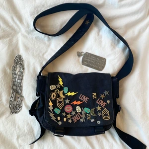 Zadig et Voltaire väska  - Asnajs unik Zadig et Voltaire väska med coola pins! Får alltid massa komplimanger när jag använder den! Köpt här på Plick men kommer tyvärr inte till lika mycket användning längre! Förtjänar ett bättre hem!🥺💕 bandet är justerbart och det medföljer en sorts kedja och en dogtag. Många praktiska fack! Man får plats med mycket! Skriv privat för fler bilder och ifall fler är intresserade blir det budgivning. Buda bara om du tänker köpa🌸