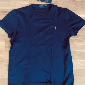 Polo t-shirt  - Helt oanvänd tshirt färgen är mörkblå fraktkostnaden behöver inte kosta 66kr kan skicka för 48kr med frimärken.