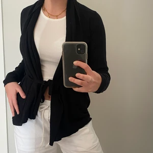 Svart Kofta - Svart kofta med justerbart snöre i midjan som man kan knyta antingen i ryggen eller i midjan ifrån Cubus i storlek XS. Jag är 163 cm och har ofta storlek S/M men den passar perfekt. Säljer den för 70kr exklusive frakt men kan mötas i Stockholm🖤