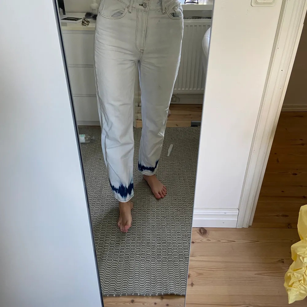 Mina vita jeans med blå batik som en rand längst ner, dessa har varit en stor favorit men har tyvärr blivit för små. De har en liten fläck på ena benet som man kan se på bilden men annars ser de nya ut! . Jeans & Byxor.