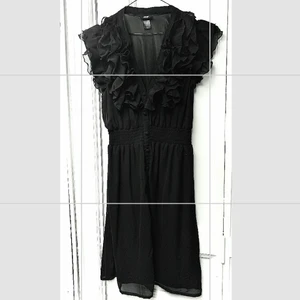 Söt svart klänning  - Söt smickrande svart klänning med fina volangdetaljer från H&M, storlek 36/38.  Resårparti i midjan därför passar även större storlek. Passar lika bra till vardags som till fest.