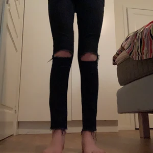Svarta jeans - Ett par jeans som är i storlek XS dem är lite fransade där nere och hål på knäna man får fin form i dem! (Vi Diskutera priset)