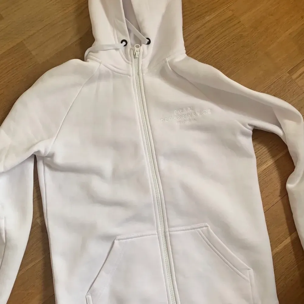 Säljer denna vita zip hoodie från Peak Performance i otroligt bra skick, knappt använd. Säljer pga att den ej kommer till användning. Skriv gärna för fler bilder🥰  nypris 1200kr!. Hoodies.