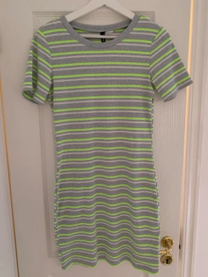 Ribbad klänning - Kort ribbad klänning från H&M i storlek medium! Jättefin med neonfärger grön och gul blandat med grå! Sitter kroppsnära men ändå väldigt stretchig och skön