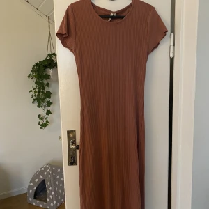 Klänning - Rosa klänning i lite tjockare tyg som går ner till anklarna. Den är väldigt slim.