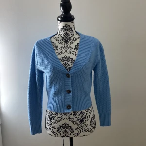 Blå cadigan/kofta - En fin blå kofta(cadigan) ifrån Mango. Köpt för ett år sen ungefär. Är i bra skick och använd runt 2 ggr. Passar bra med en vit croptop under eller en enkel, tunn, kortärmad tröja!