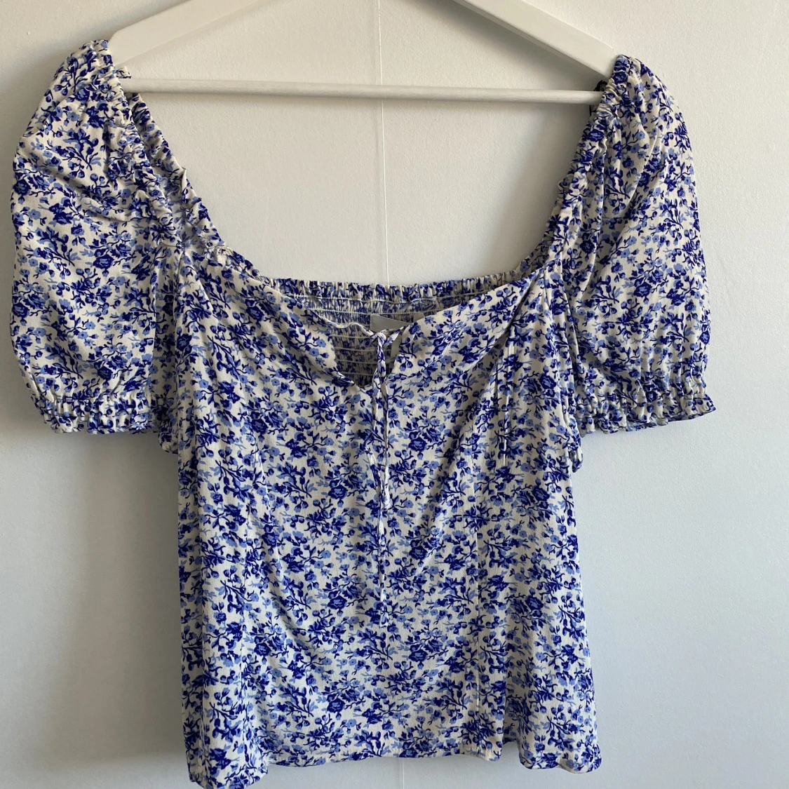 Vit topp med blå blommigt mönster