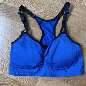 Blue sports bra in stretch fabric, size S. Comes with padding and adjustable straps
