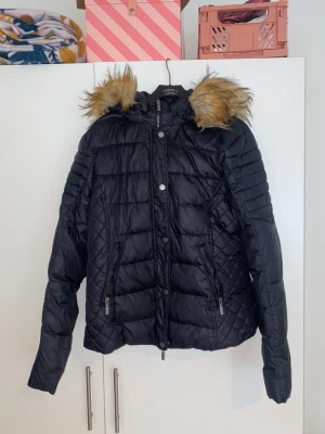 Vinterjacka med päls  - En svart figursydd vinterjacka med avtagbar luva 😊