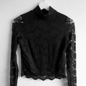 Spetströja  - Svart spetströja som visar magen lite från Gina Tricot i storlek S. Öppen i ryggen och har tre knappar i nacken. Tycker denna passar XS också. 