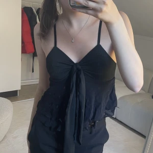 Svart topp med rosett - Svart topp med rosett🩷 Använd 1 gång💕Säljer för 75kr+frakt🤩