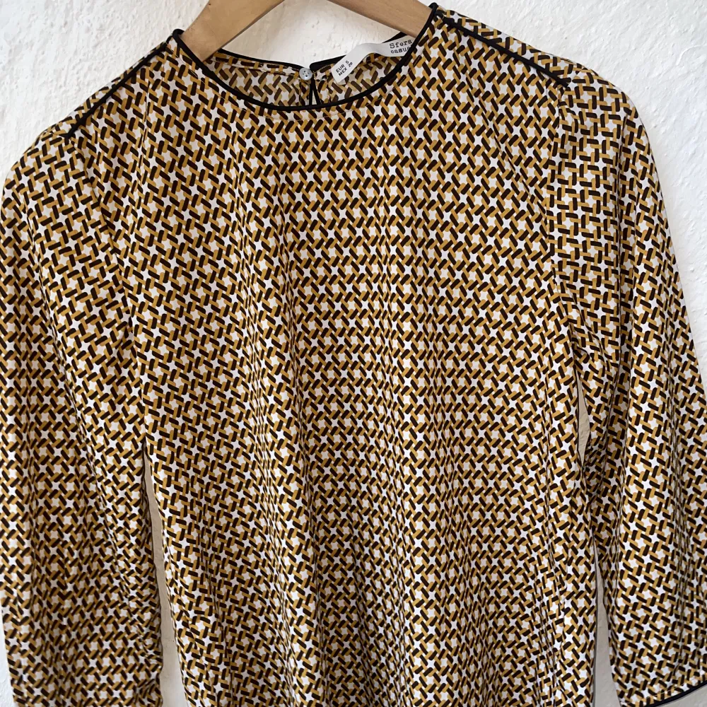 Wonderful material, pattern and small details. Long sleeves mustard yellow and brown pattern. . Blusar.