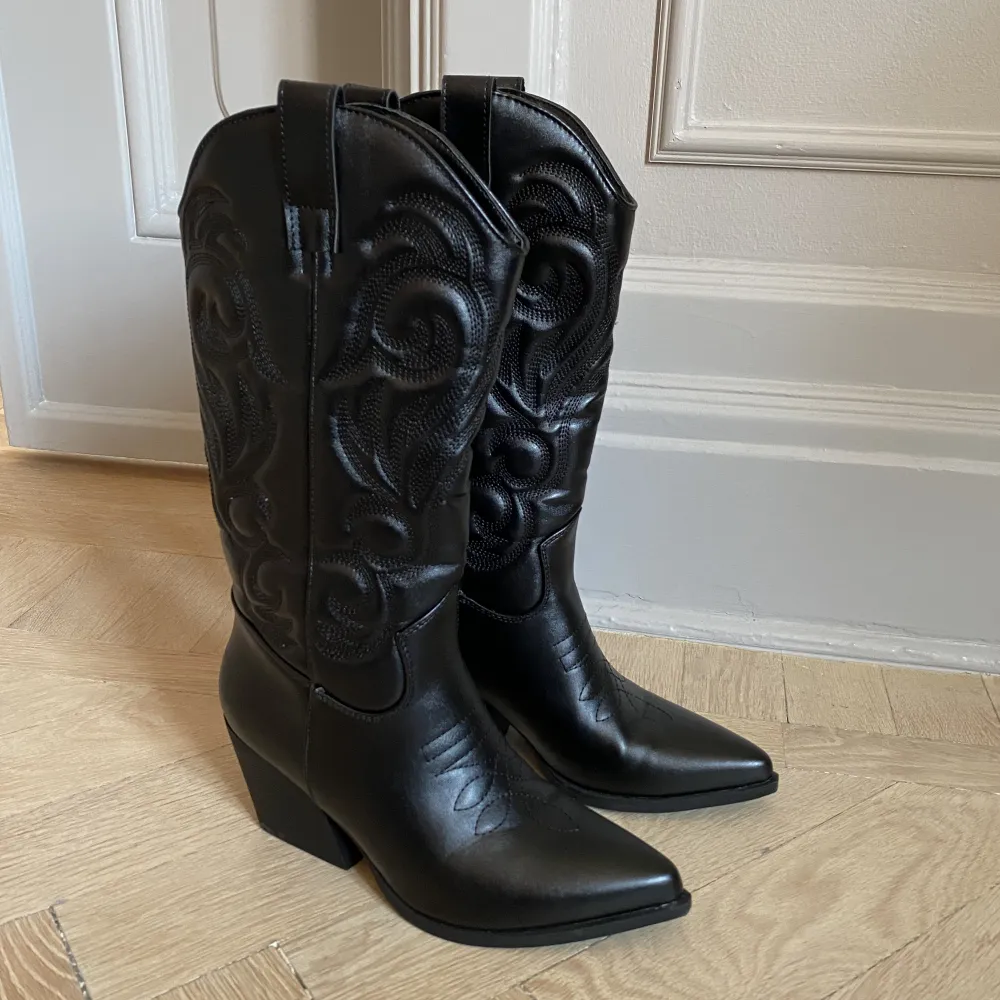 Ett par assnygga svarta cowboy boots som endast är använda 1 gång så de är nästan helt i nyskick. De är så bekväma för de har ett foder som gör att man inte får skavsår. De är i storlek 36 men jag har storlek 37 och det passar super bra. Bekväm klack. . Skor.