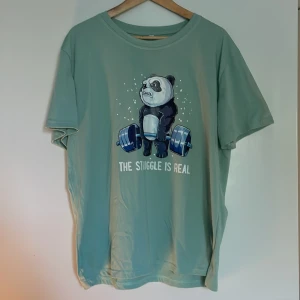 T-shirt med tryck - Fin grön t-shirt i XXL, funkar fint som oversized t-shirt. Gulligt gym-tryck med panda. Väldigt fint skick. Allt ska bort så pris kan diskuteras💗