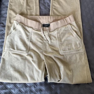 Juicy Couture byxa -  Säljer mina beiga Juicy Couture Byxor då jag inte använder dem längre. De är storlek L men passar mig som oftast bär storlek M. Nypris 1199 kr