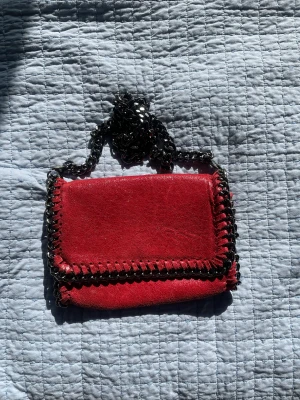 Röd väska - Jätte fin röd Stella McCartney liknade väska. Köpt här på Plick, men näst intill aldrig använd. Inga synliga defekter. Vet desvärre inte märket på väska, eftersom den är köpt på Pilck. Använd gärna inte ”köp” funktionen, skriv till mig istället💘