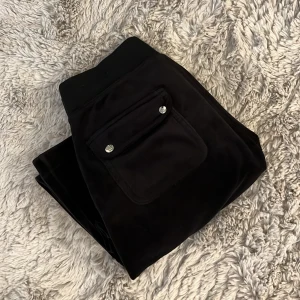 Juicy couture byxor - Svarta Juicy Couture byxor i storlek xs. Fint skick, Dom är uppsydda hos en skräddare så innerbenslängden är 74 cm, passar mig som är cirka 160. Dom är även insydda lite vid låren så att dom ska sitta tajtare där. Nypris 1200 
