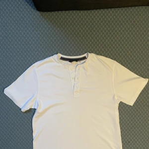 Bonaparte T-shirt  - Vit Bonaparte T-shirt med 3 knappar. Endast 40 spänn.