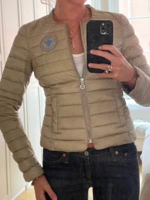 Morris jacka - En biege tun dunjacka från Morris. Ljusblå morrislogga. Oanvänd. Perfekt för hösten.