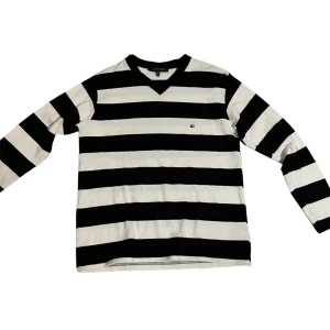 Tommy Hilfiger Långärmad Tröja - En Tommy Hilfiger långärmad tröja i storlek L. Svart/vit randig. I nyskick.