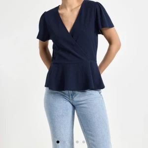 Peplumtopp med kort ärm från Lindex - Jättefin mörkblå topp från Lindex som endast använts 1 gång💕är i storlek M men passar även S. Den är i jättefint skick o är prefekt till lite finare tillfällen💖Den har vallans armar o är jätteskön. 200 +frakt💕