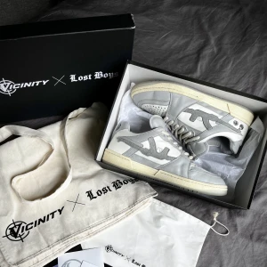 Lost boys x Vicinity low top sneakers - Skor, stl. 45, Herr Limited edition Lost Boys skor i färg ”Stormy Grey” och stl 45 ink original box, tygväska, dekaler och tygpåse säljes för 1400kr. Sparsamt använda och i fint skick! Skorna finns på Södermalm. Kan även postas mot betalning. 1400 kr