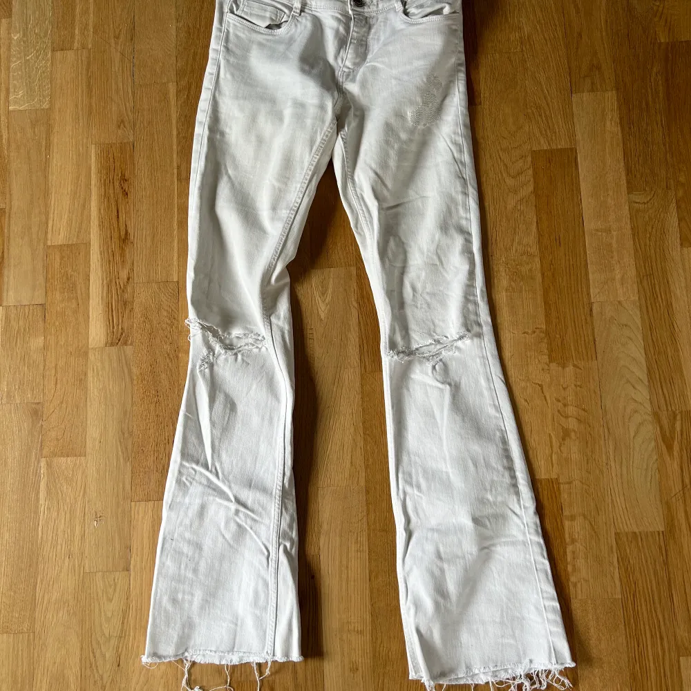 Vita lågmidjade jeans med lite slitningar från Zara Storlek 36. Jeans & Byxor.