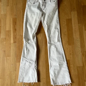 Vita jeans - Zara - Vita lågmidjade jeans med lite slitningar från Zara Storlek 36