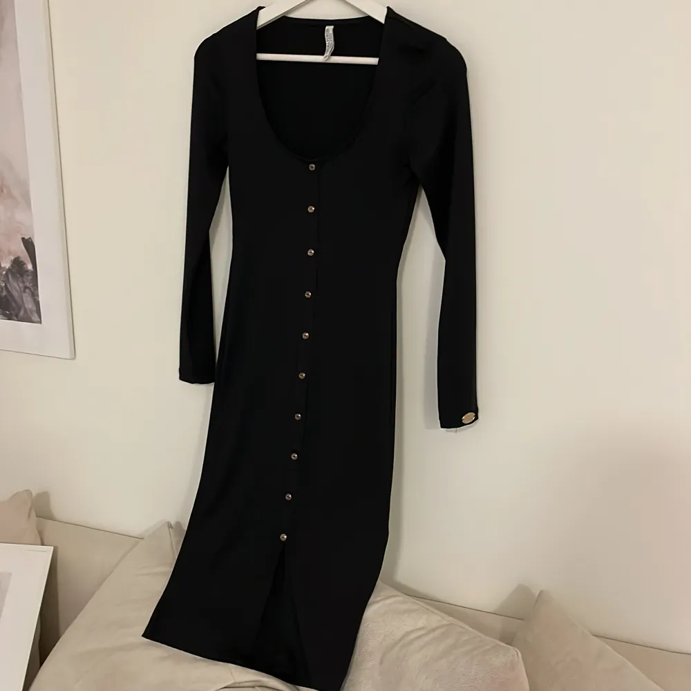 En svart basic klänning med en sluta längst ner. Klänningar.
