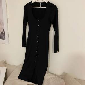 En svart basic klänning med en sluta längst ner