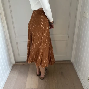 Söt prickig kjol - Fin prickig kjol med vackert fall. Storlek 38.