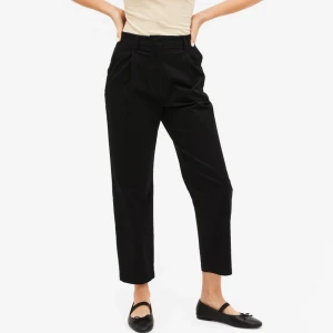 Oanvända svarta chinos byxor, Strlk 34. Helt felfria. - Oanvända svarta chinos, Strlk 34. Har fickor och hällor för skärp. Material: bomull. Helt felfria. Första bilden är ett exempel på liknande modell och passform.