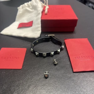 Valentino armband - Säljer mitt assnygga valentino armband i bra skick. NYPRIS ca 2900kr. Tillkommer: allt på bilden (armband, box, dustbag, ”äkthetsbevis” och extra nitar). Skriv vid minsta lilla fråga och har såklart fler bilder om du vill. 