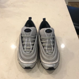  Nike Air Max 97 silver blå  - Ny pris 2049kr från Nike men säljer dom för 550kr har haft dom i cirka 1 år. Dock har höger sko ett litet håll i bubblan men märks knappt.