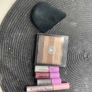 Smink - 3 glittriga eyeliners, en eyeshadow i blöt form, ett ögonskuggs pallet med 5 olika ögon skuggor! En puder puff! Allt är oanvänt, ögon skuggs paletten ser använd ut på den glittriga men det var så när jag köpte den! Hoppas någon vill köpa!😻
