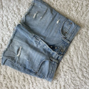 Jeanskjol från LEVIS - Kort jeanskjol från Levis. Sliten modell. Storlek 28. Bra skick. 
