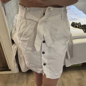 Vit kjol HM - Vit kjol i linneblandning från HM. Aldrig använd. Dragkedja i sidan. Storlek 46. Köpare står för fraktkostnad.